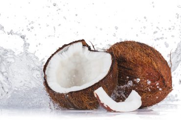 Kokos: Eine geöffnete und eine geschlossene Kokosnuss