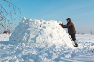 Leben wie die Eskimo oder Inuit - Ein Mann baut ein Iglu