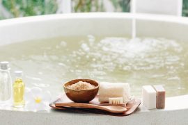 Entspannung zu Hause: befüllte Badewanne mit Wasser und Pflegeprodukte auf dem Rand