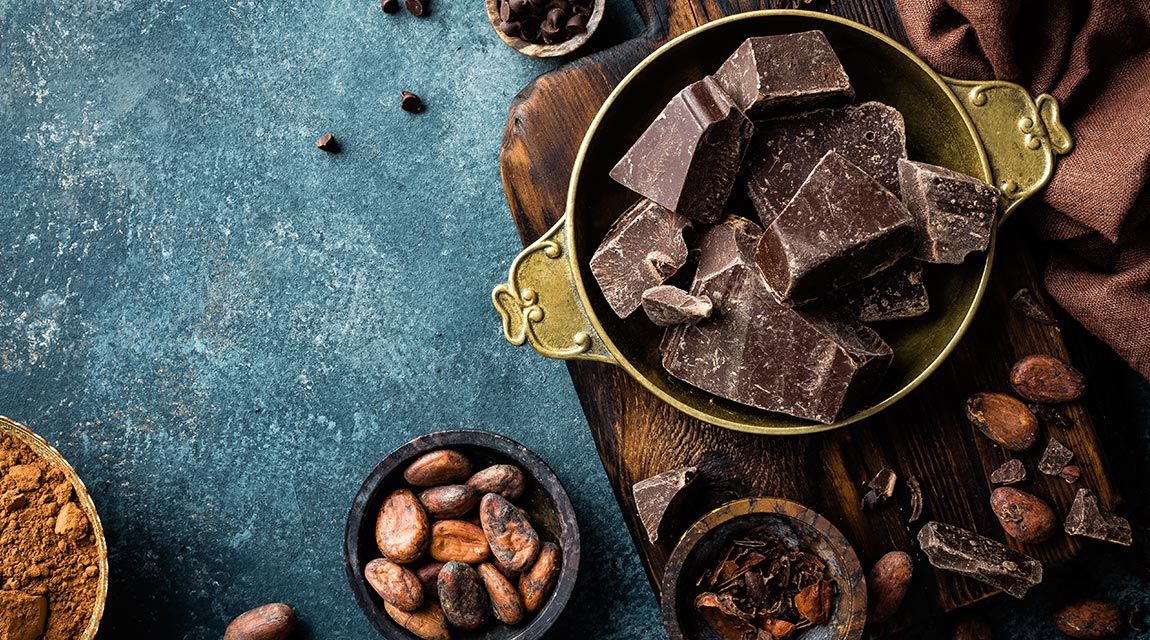 Schokoladestücken und Kakaobohnen in Schüsseln