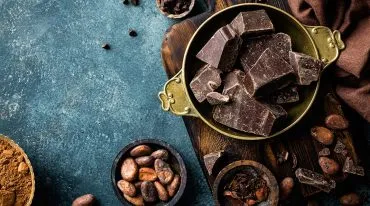 Schokoladestücken und Kakaobohnen in Schüsseln